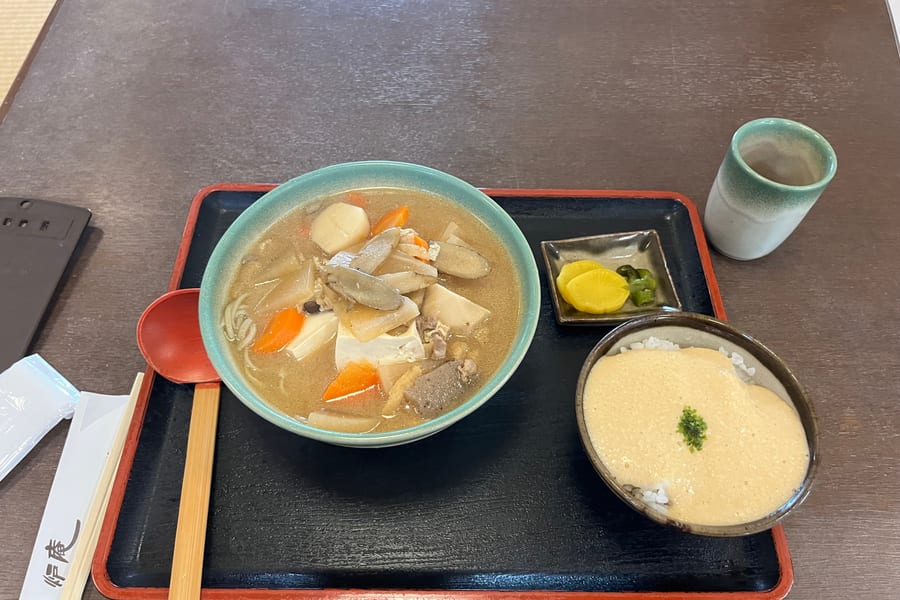 Hand-rolled soba noodles served in a rustic bowl at a countryside restaurant