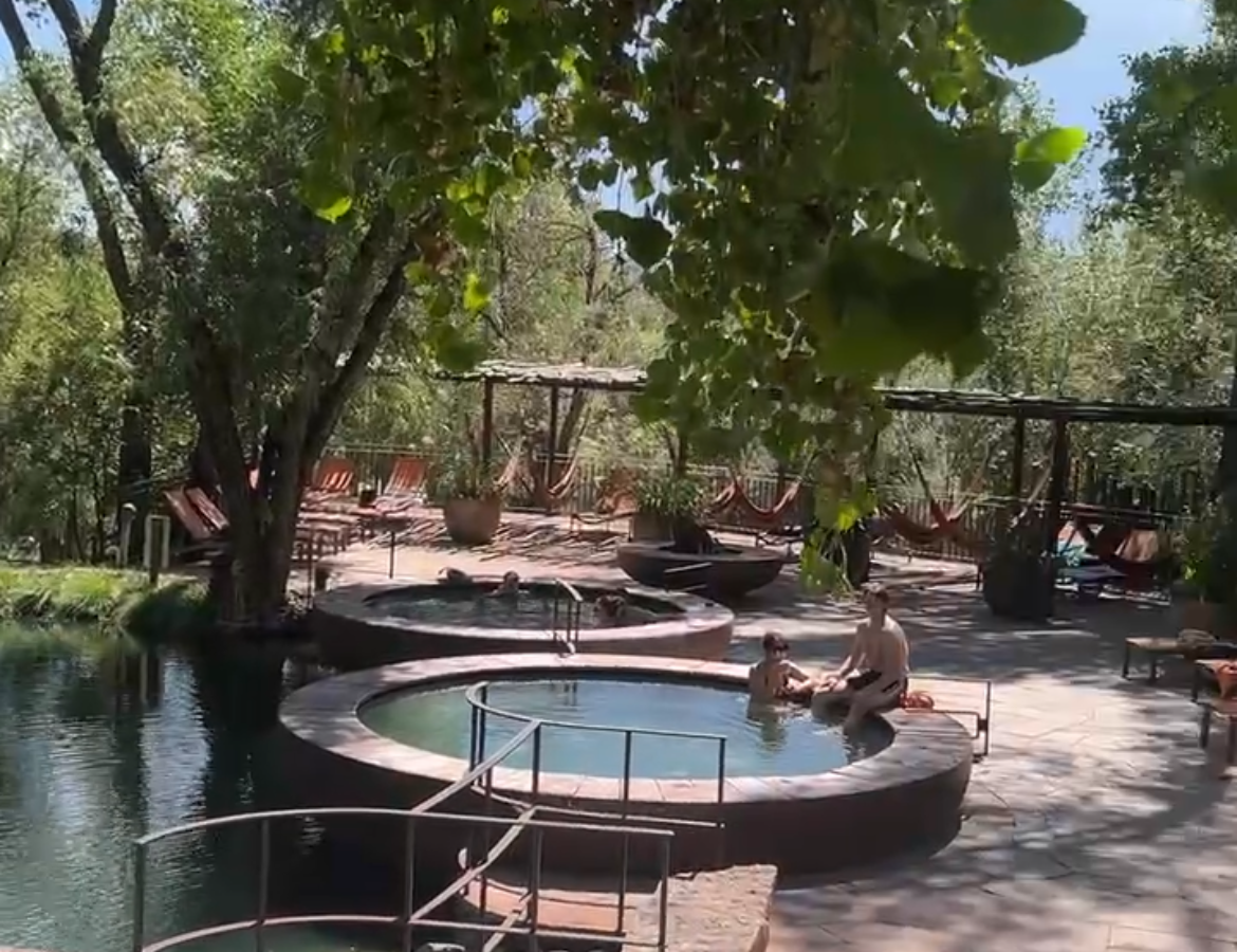 Ojo Santa Fe Spa Resort outdoor mineral pool complex surrounded by mature cottonwood trees and natural landscaping
