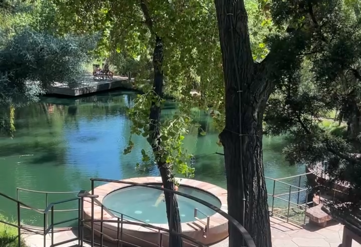 Ojo Santa Fe circular mineral soaking pool overlooking the tree-lined river, Santa Fe New Mexico