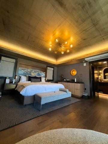 Orli La Jolla guest room with gold-leaf ceiling, Sputnik chandelier, and king bed dressed in white linens