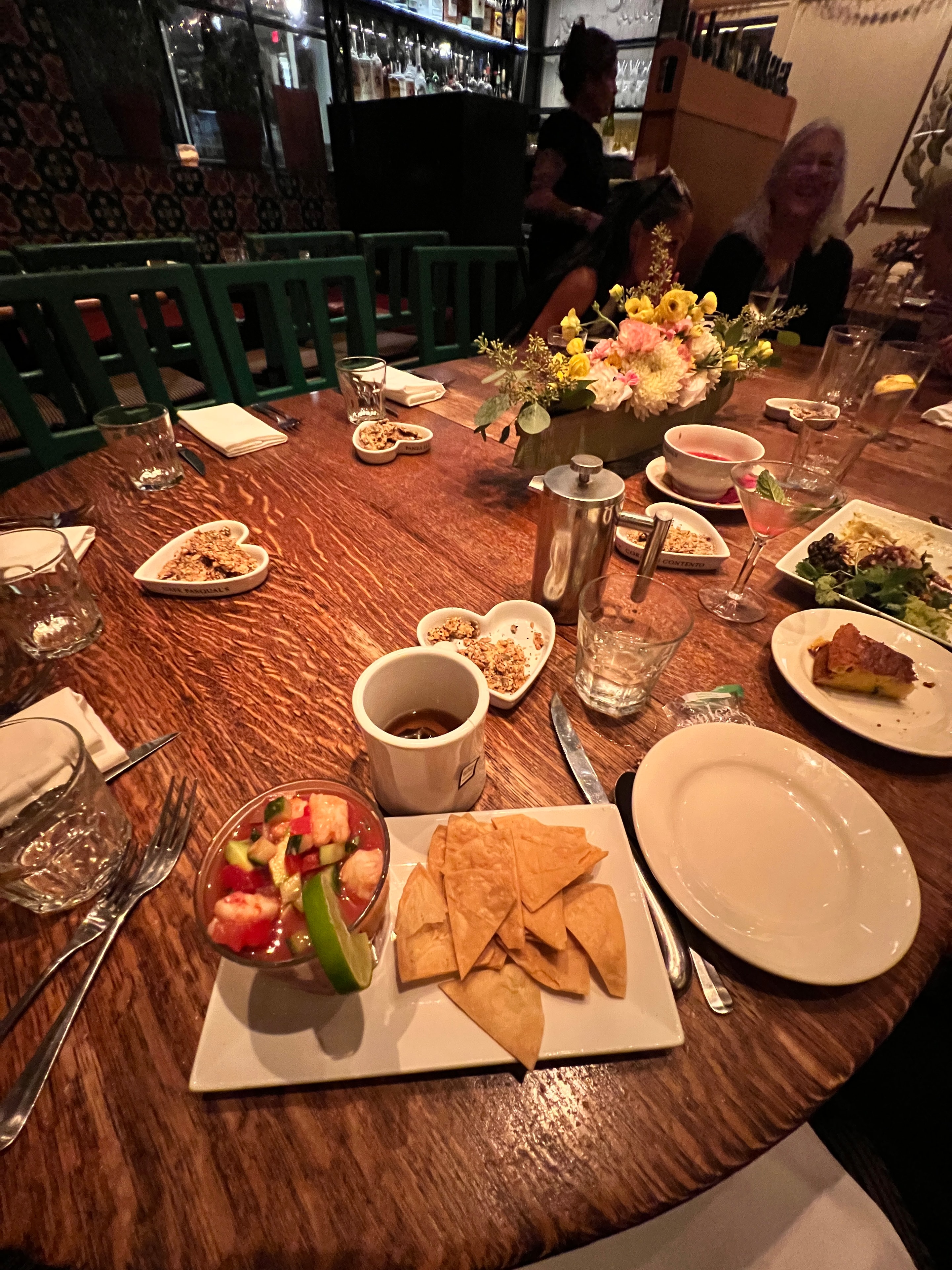The interior of Cafe Pasqual's Santa Fe — murals, warm light, and the legendary community table